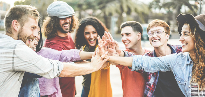 Junge Menschen bilden einen Kreis und halten in der Mitte ihre Hände zusammen um den Teamgedanken zu symbolisieren Junge Menschen bilden einen Kreis und halten in der Mitte ihre Hände zusammen um den Teamgedanken zu symbolisieren