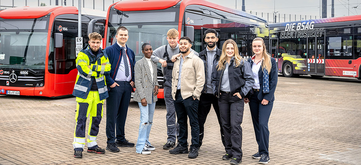 Acht Auszubildende aus verschiedenen Bereichen, im Hintergrund drei Busse der BSAG Acht Auszubildende aus verschiedenen Bereichen, im Hintergrund drei Busse der BSAG